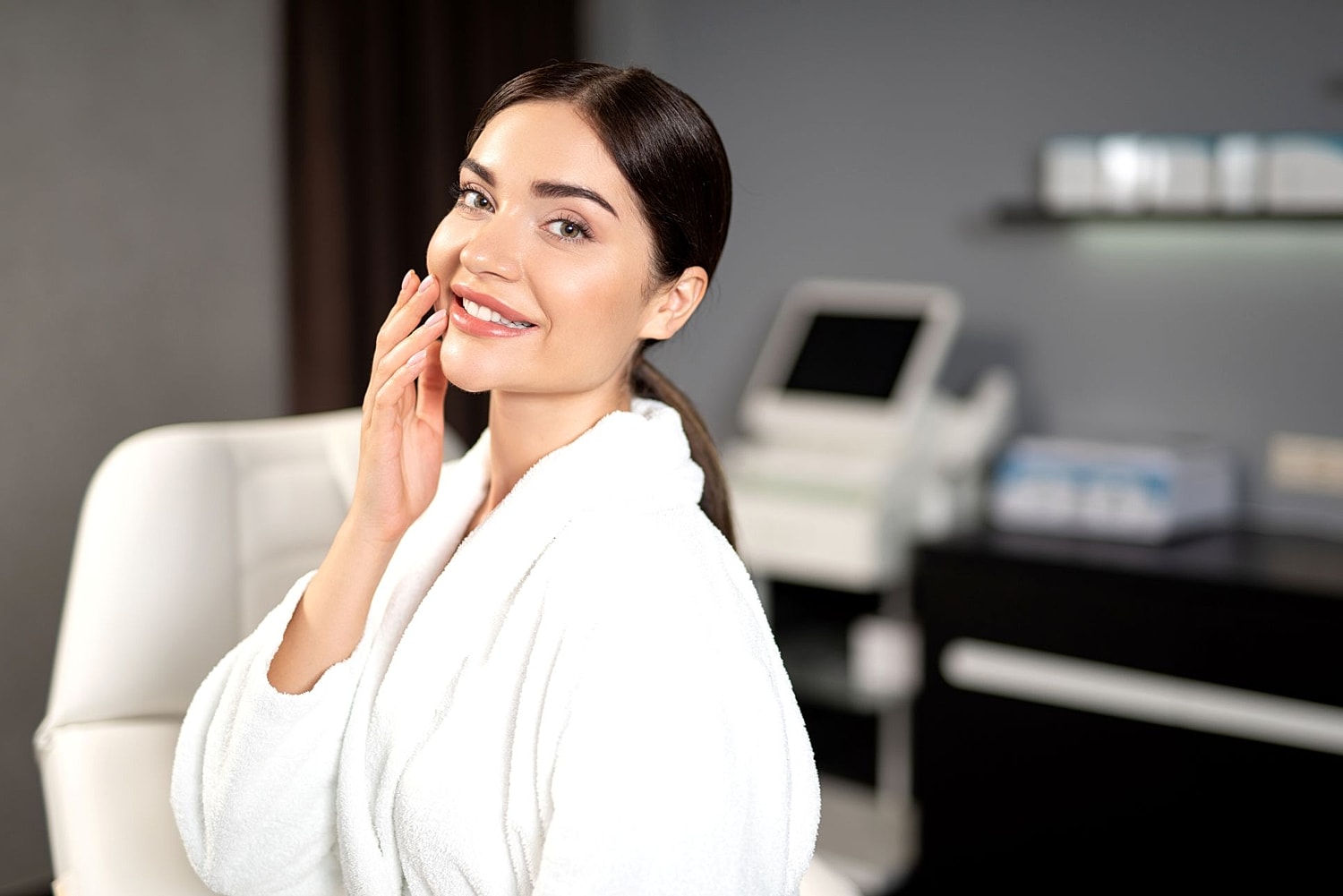 Woman in spa robe smiling at camera.