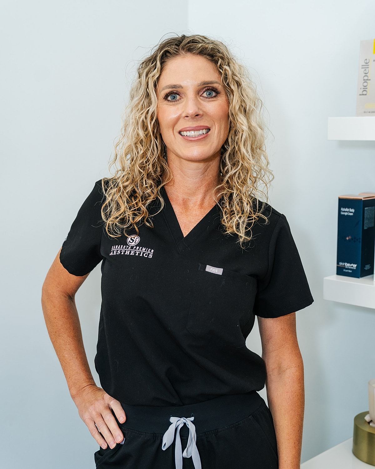Woman in scrubs smiling at the camera