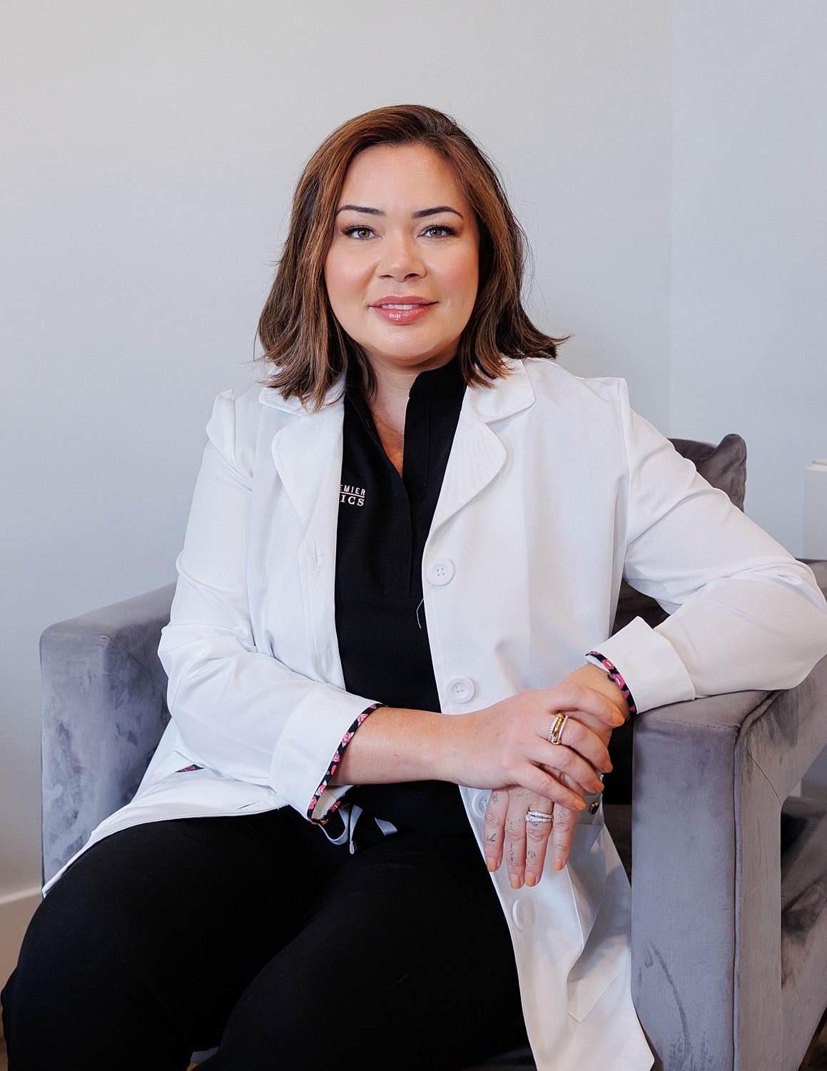 Young woman in chef's attire smiling at camera.